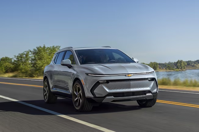 A 2024 Chevrolet Equinox EV driving on the road.