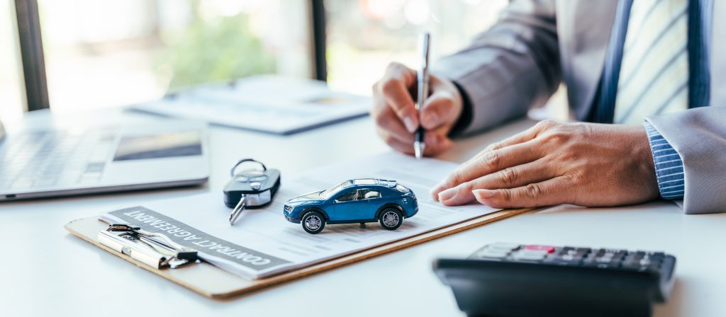A man signing auto loan financing paperwork