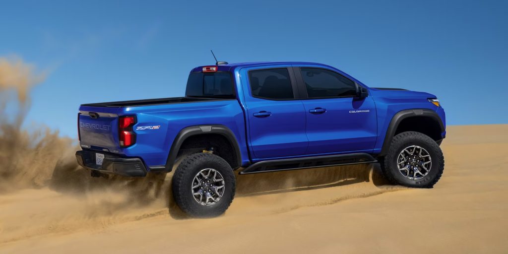 a royal blue 2025 chevy colorado off-roading on the beach
