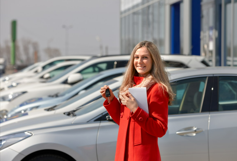 A woman with a red coat showing off the keys to her brand new Chevrolet